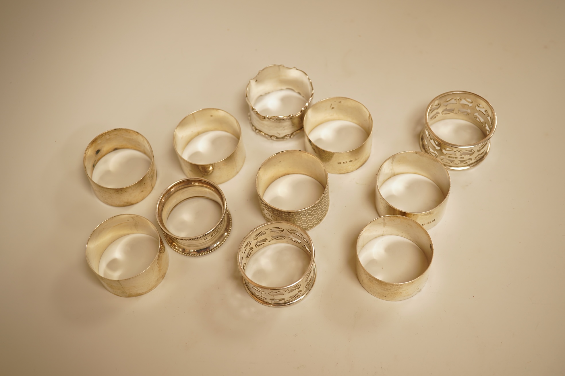 A pair of Edwardian pieced silver napkin rings by Henry Wigfull, Sheffield, 1905, together with nine other assorted silver napkin rings.